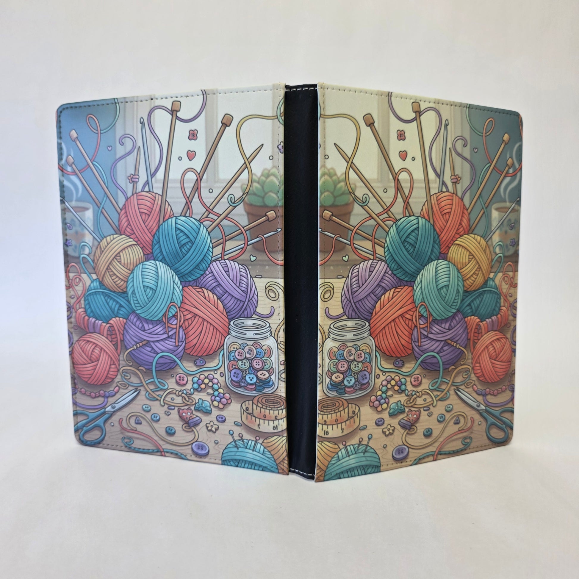Notebook cover with colorful yarn balls and knitting tools.