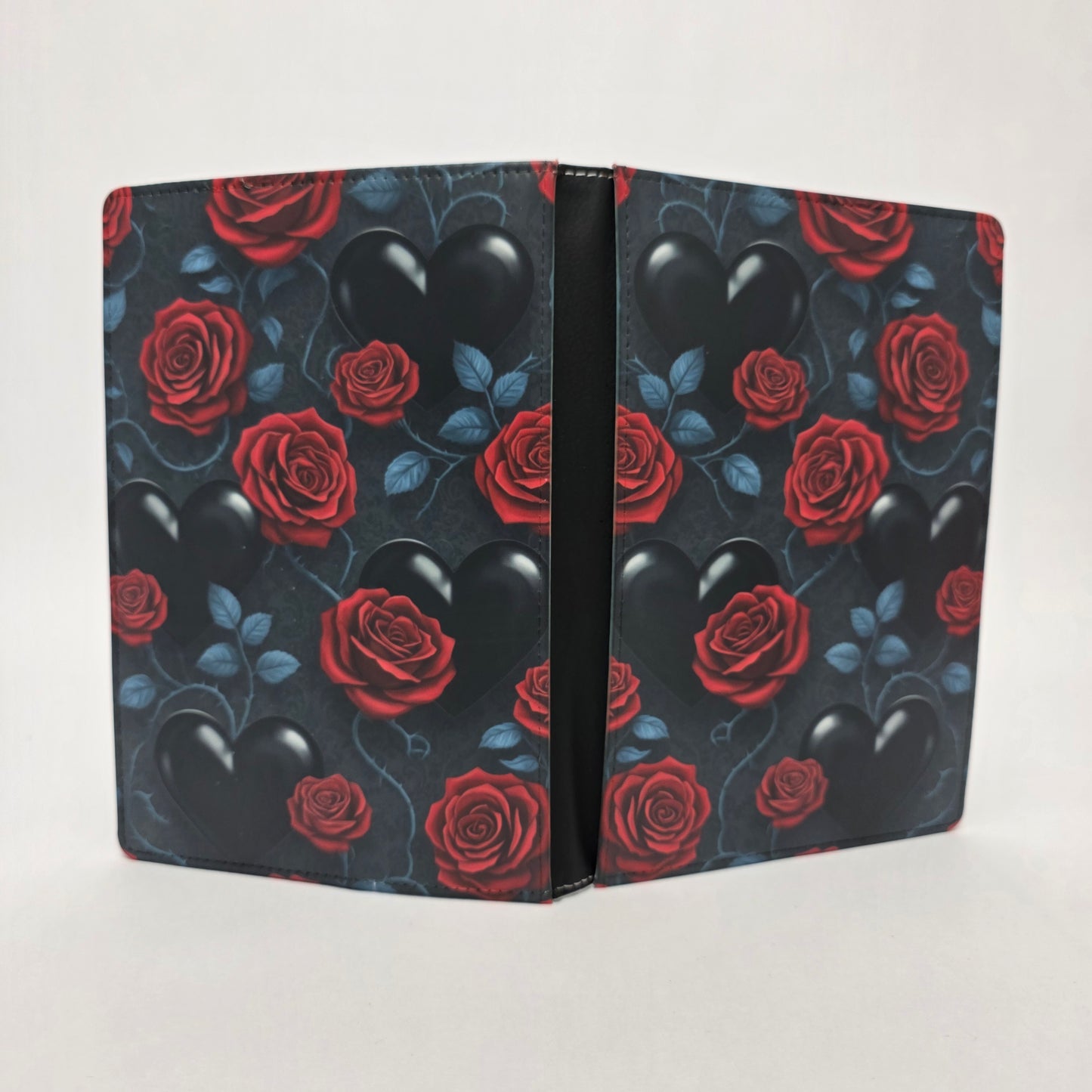 Journal cover with red roses and black hearts on a dark background. Vines and leaves curving around the hearts and roses.