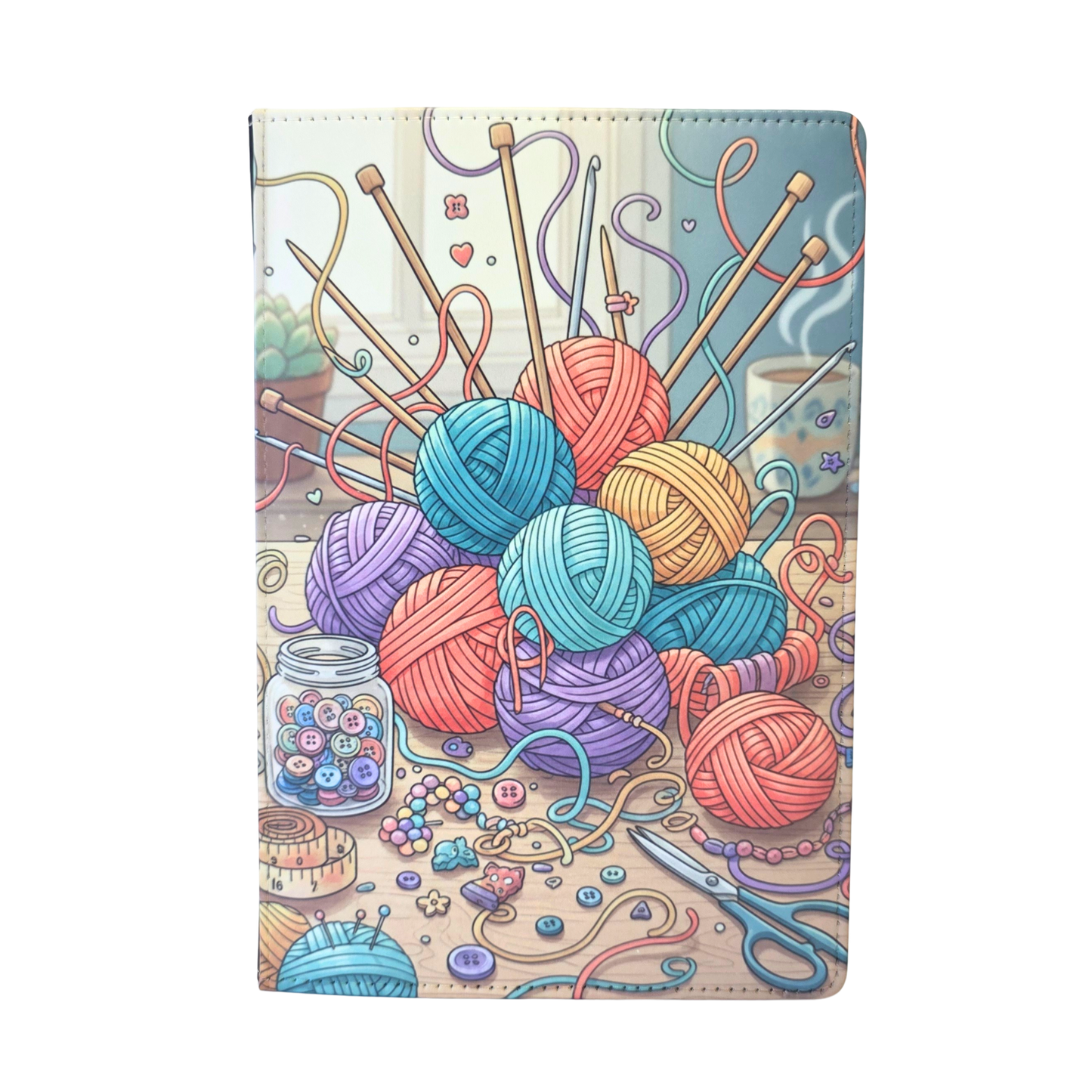 Notebook cover with colorful yarn balls and knitting tools.