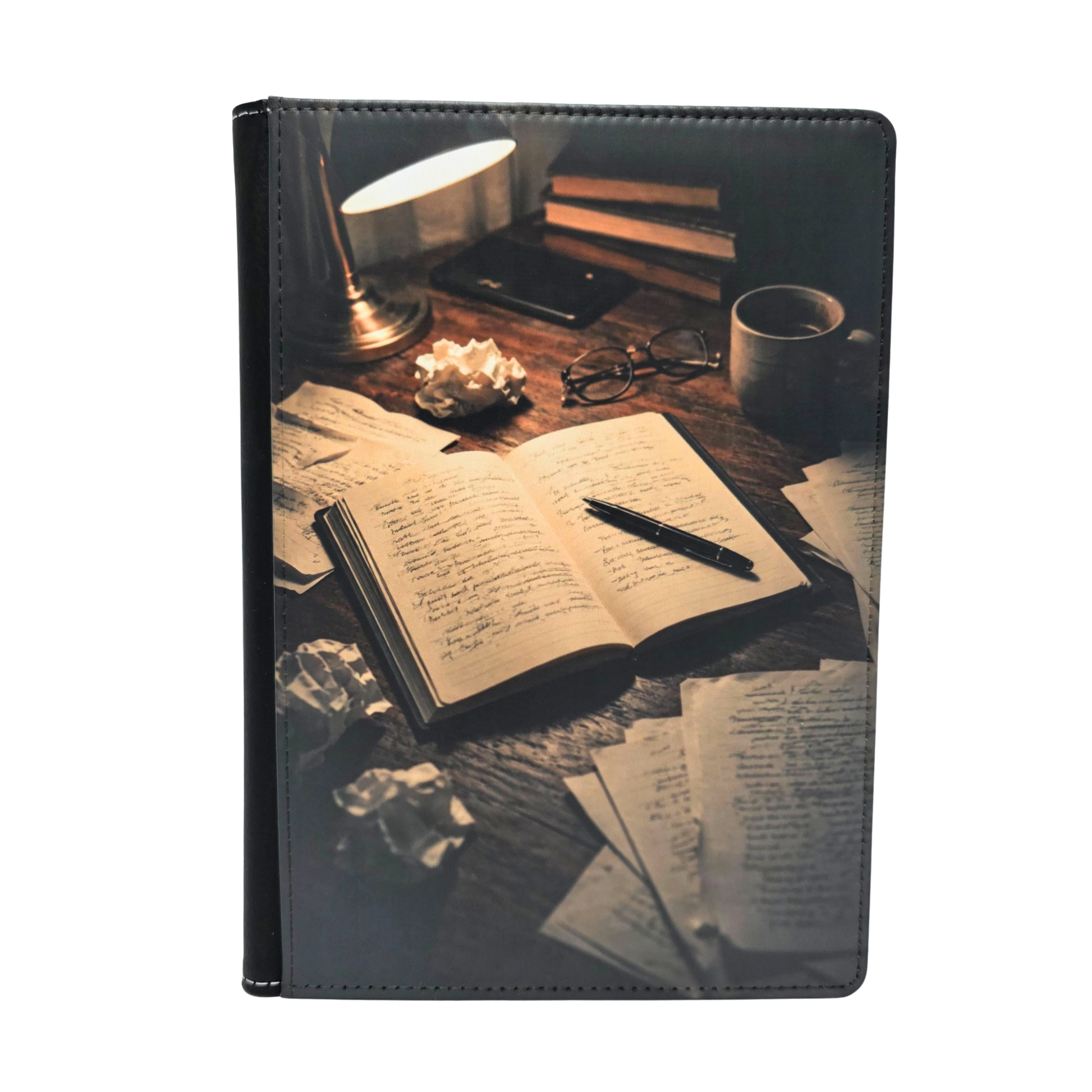 Journal cover with a design of an open book and writing utensils on a desk.