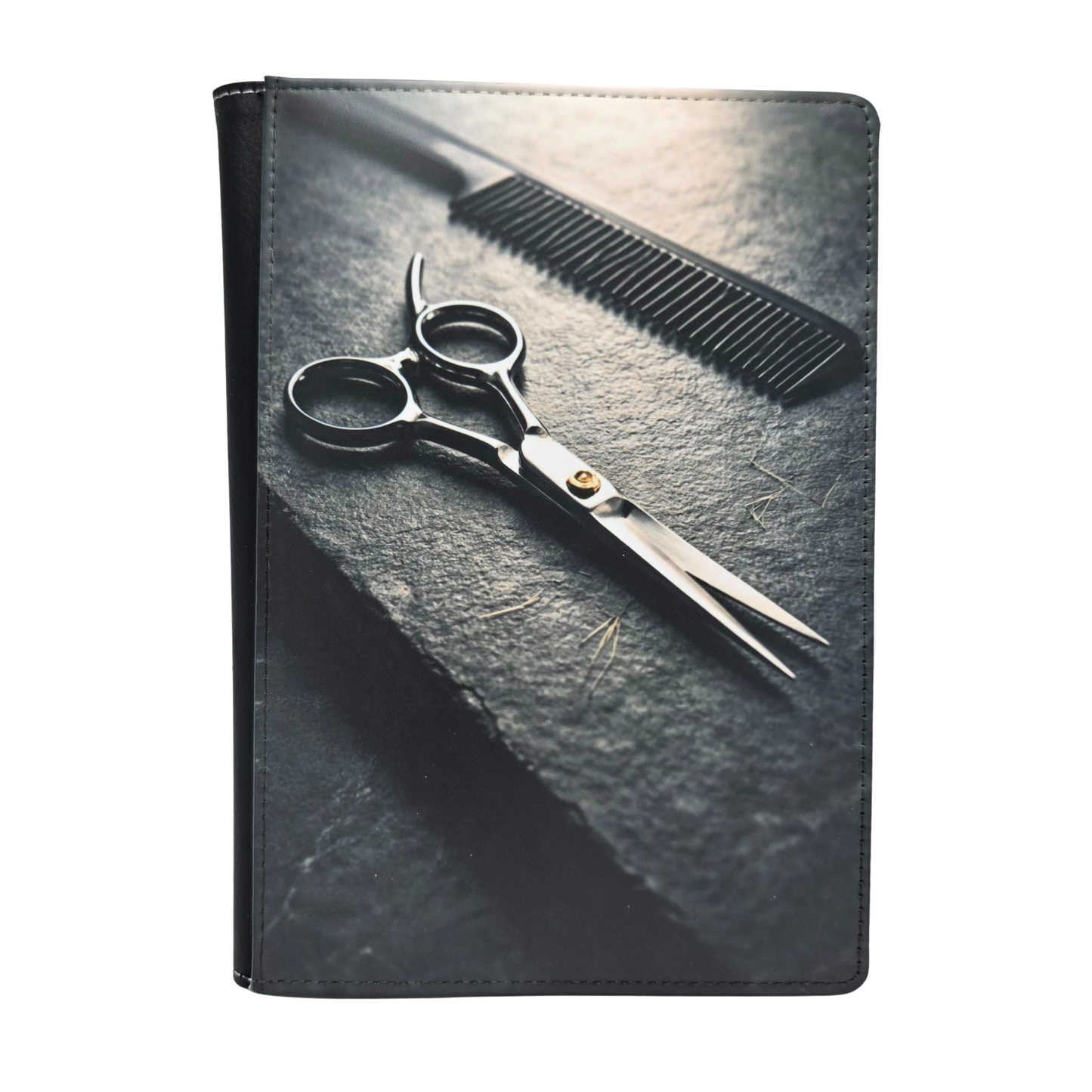 Scissors and comb on a textured slate surface. Grayscale color.