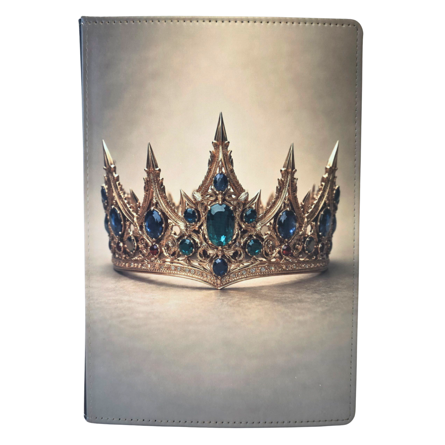 A journal cover with a gold crown and emerald stones on a tan background.