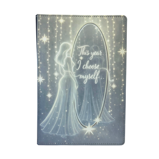 Journal cover with a silhouette of a woman looking into a mirror and 'This year I choose myself' text on the mirror. Yellow and gray tones, with a slight glow.